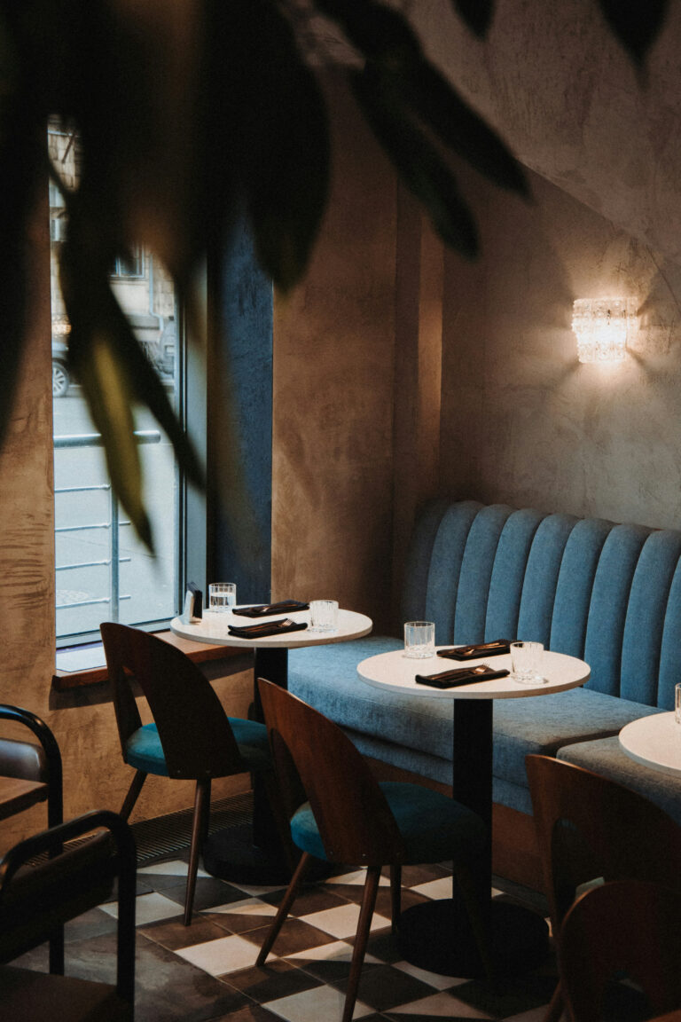 Doftmarknadsföring En mysig restauranginteriör med sittplatser vid små bord och mjuk belysning.